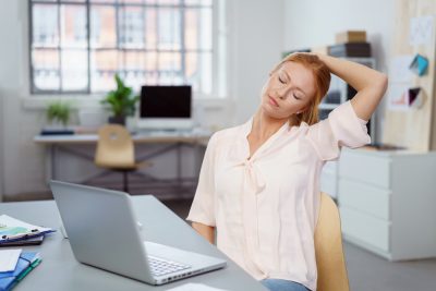 woman stretching in office desk